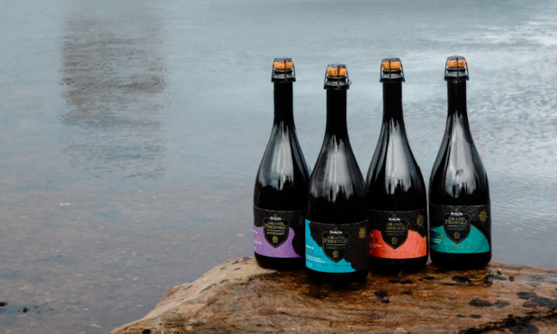 Vier flessen Hertog Jan Grand Prestige Vatgerijpt 2020 op een steen voor een meertje